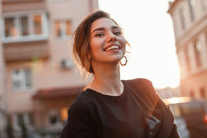 woman smiling in the city after learning about lovett dental Jersey Village and the Jersey Village TX dentistry services