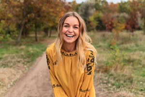 woman smiling outside in nature after visiting the Jersey Village TX cosmetic dentist for cosmetic dentistry in Jersey Village TX