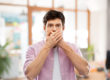 man covering his mouth worried about the causes of bad breath