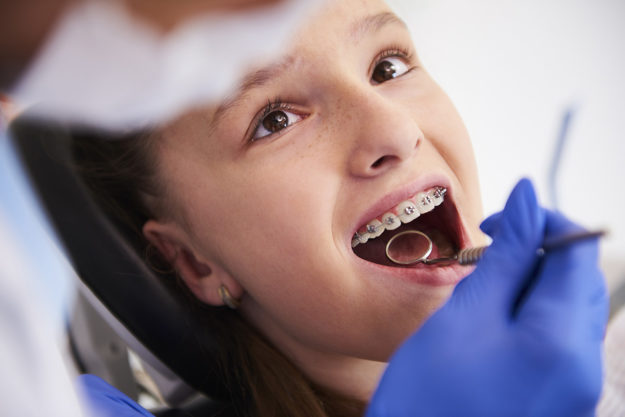how to prevent teeth shifting (1) child with braces at dentist learning How to Prevent Teeth Shifting