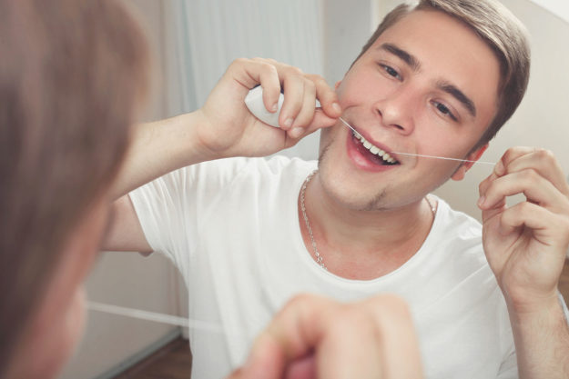 man experiencing the benefits of flossing daily
