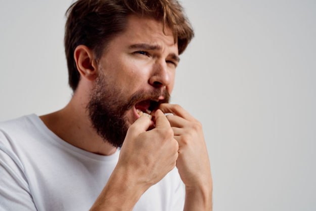 man in pain wondering how does tooth decay develop