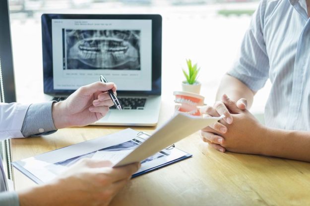 What Is A Dental Emergency (1) people discuss a dental emergency with xrays