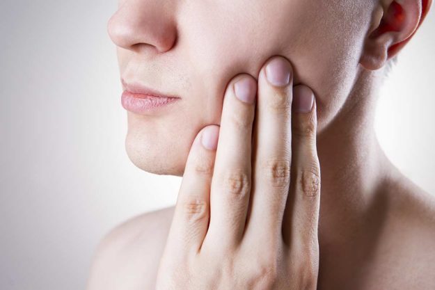 abscessed tooth woman struggles with an abscessed tooth